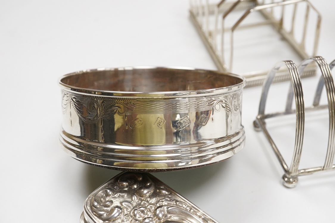 A George III engraved silver helmet shaped cream jug, Henry Chawner, London 1788(repair), height 15.3cm, together with two George V silver toast racks, a silver mounted glass toilet jar and a modern silver mounted bottle